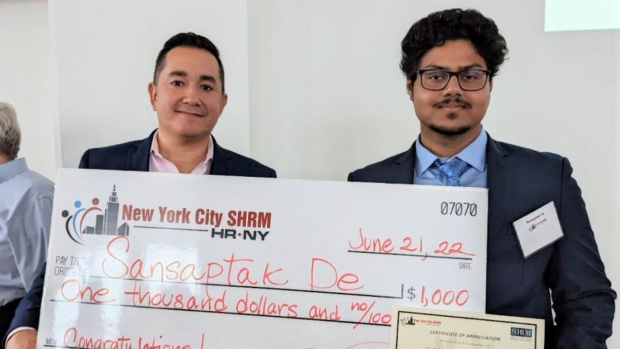 Sansaptak De and another man with a large check and a certificate