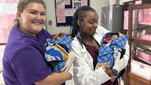 2 women holding newborn infants 