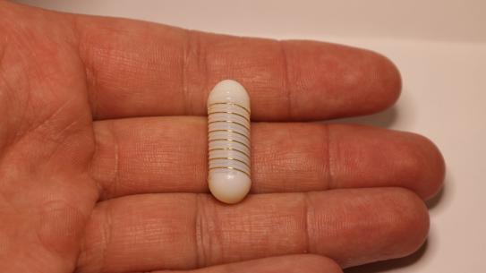 pill held in hand, larger than finger width