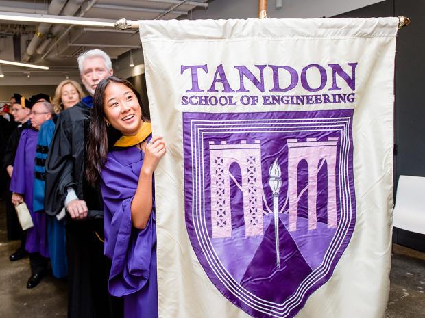 student holding Tandon banner