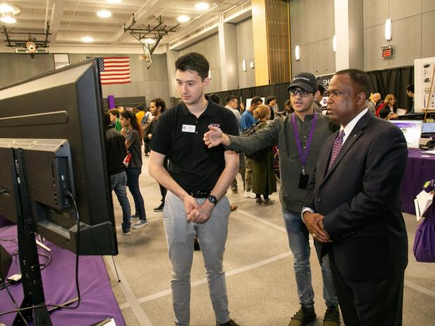 a student explains a project to industry reps