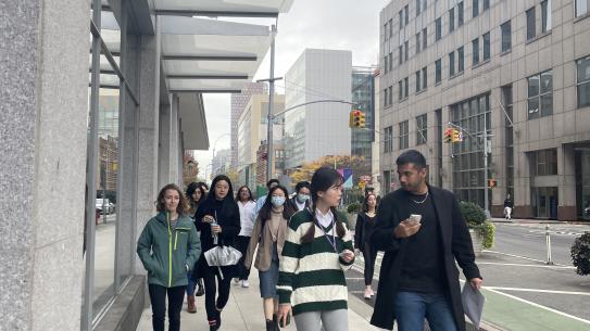 A group of CUSP students walks down the street on campus. 