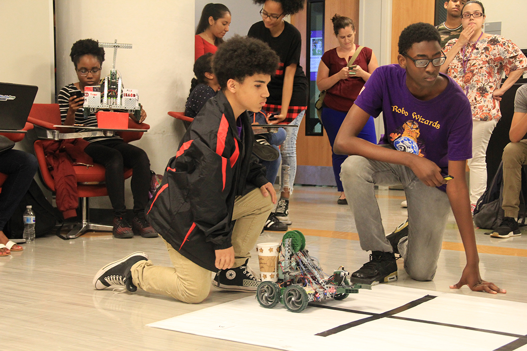ITEST students watching their robots move in a competition 